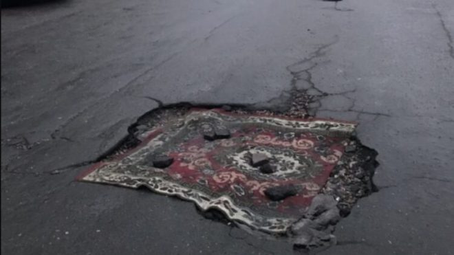 В Черкассах местные жители заделали яму в дороге ковром