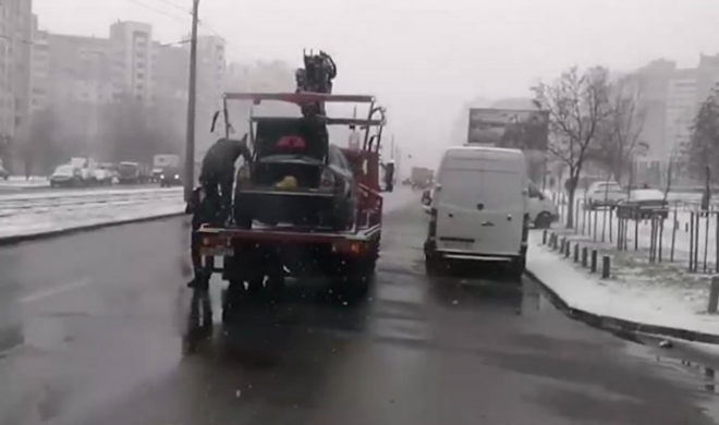 В Киеве мужчина запрыгнул на эвакуатор «спасать» свое авто