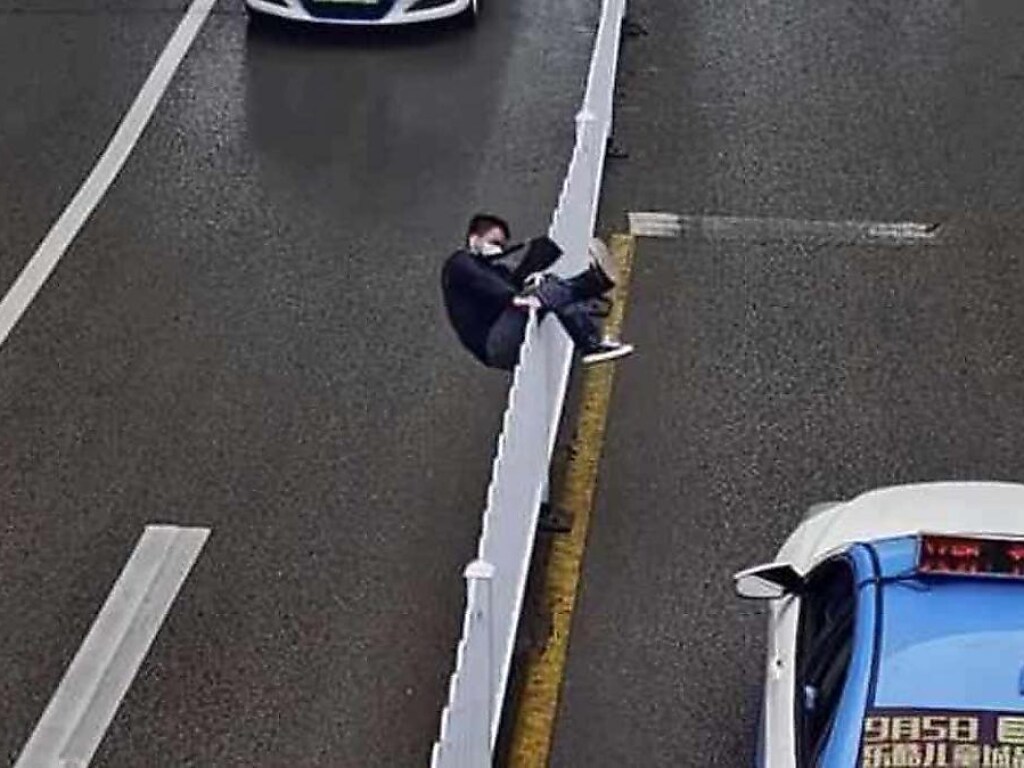Неуклюжий китаец хотел перелезть через забор на трассе и рассмешил Сеть (ФОТО, ВИДЕО)